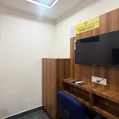 Work desk and LED TV in a room at Hotel Maruti R Ambli Bopal
