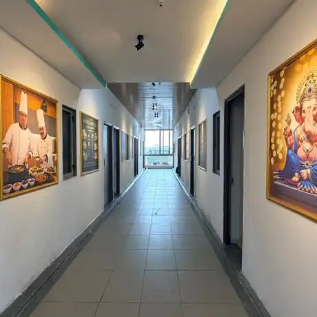 Bright guest room corridor with framed artwork at Hotel Maruti R South Bopal