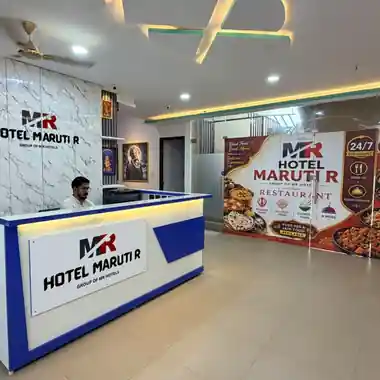 Reception desk beside the restaurant entrance at Hotel Maruti R South Bopal