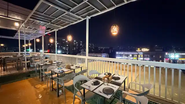 Rooftop restaurant at Hotel Maruti R South Bopal, Ahmedabad, with city views at night