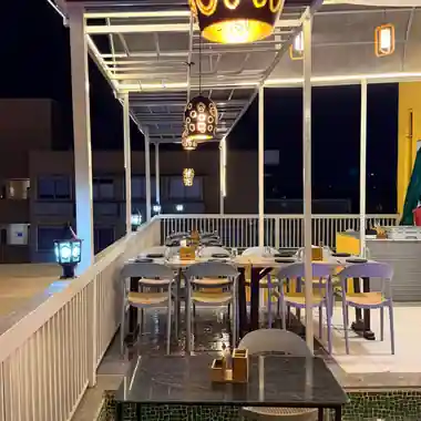 Covered rooftop terrace dining area at Hotel Maruti R South Bopal at night